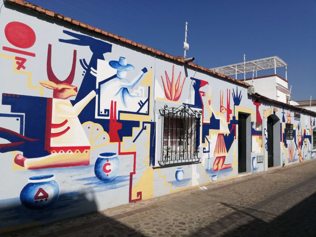 painted murals in Oaxaca City with blue, red, and white colors depicting a deer and some geometric shapes